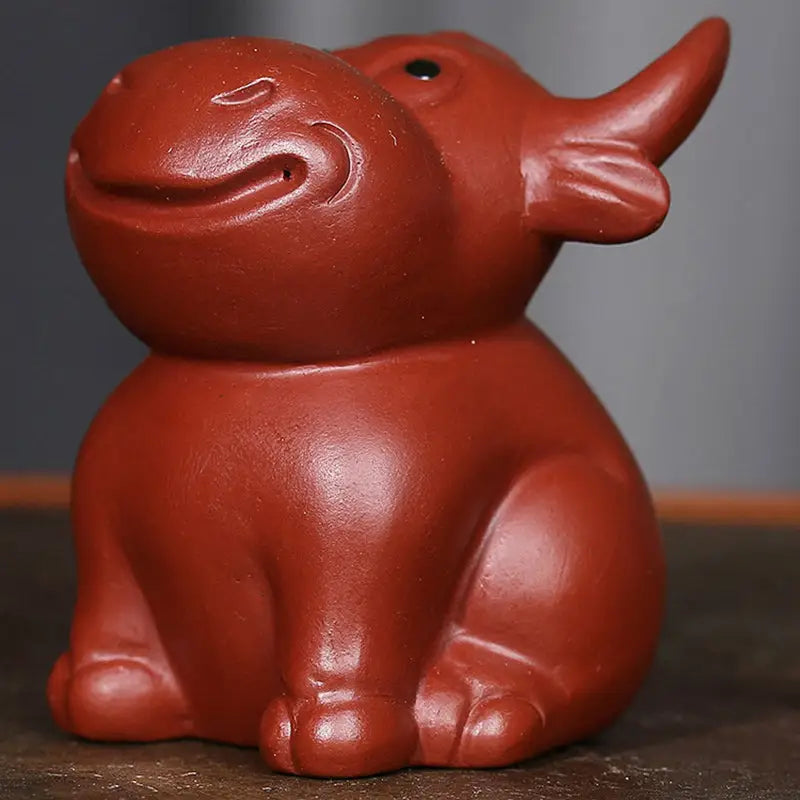 Red ceramic rhino figurine from Prosperhorn, ideal tea pet guide and feng shui earth element