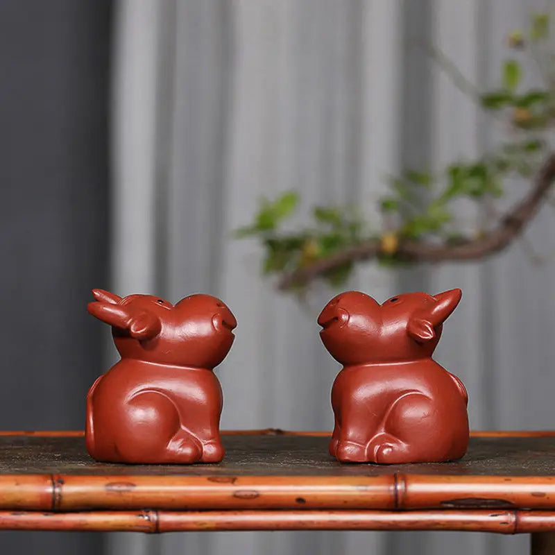 Two reddish-brown ceramic ox figurines for Prosperhorn tea pet guide, feng shui earth element