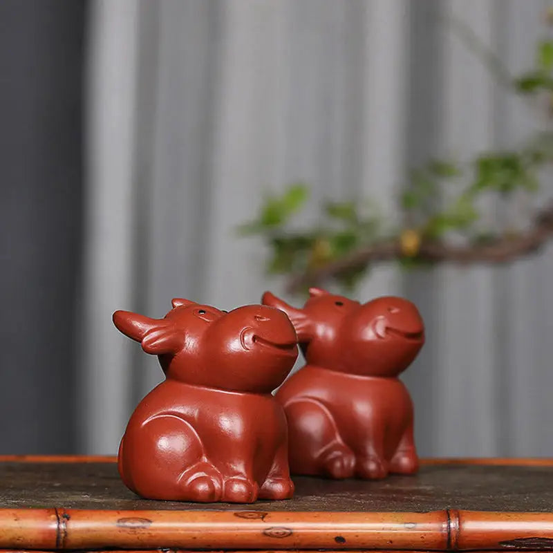 Two reddish-brown ceramic ox figurines for Prosperhorn tea pet guide feng shui earth element