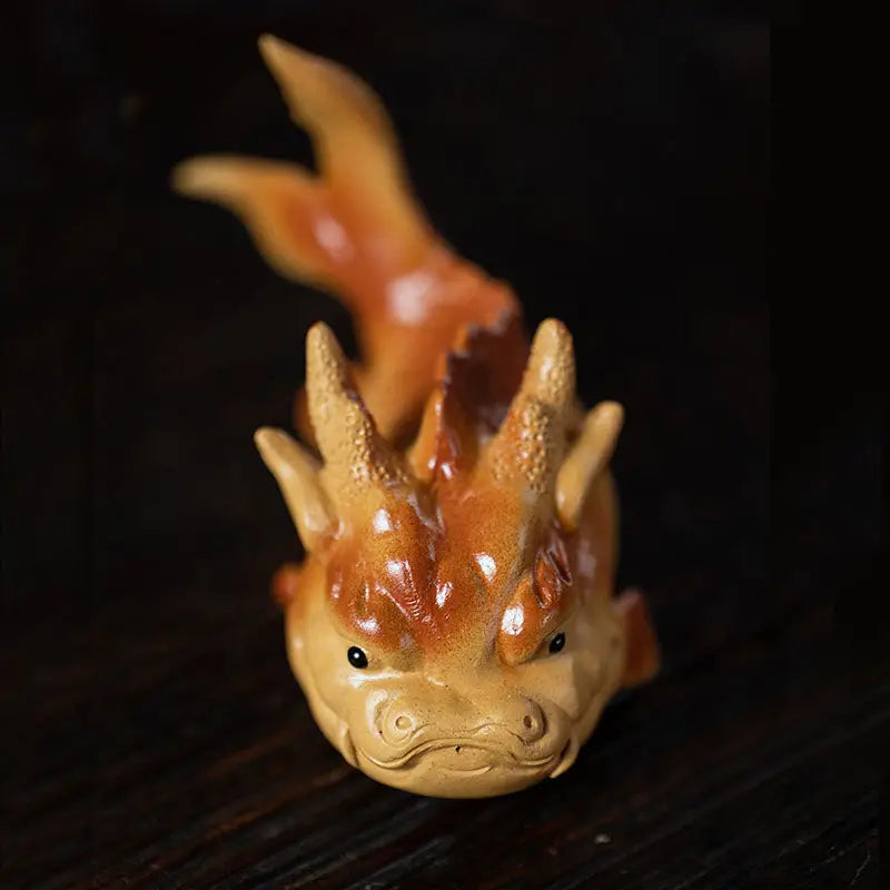 Orange dragon figurine as a fish tea pet symbol of love and feng shui good fortune