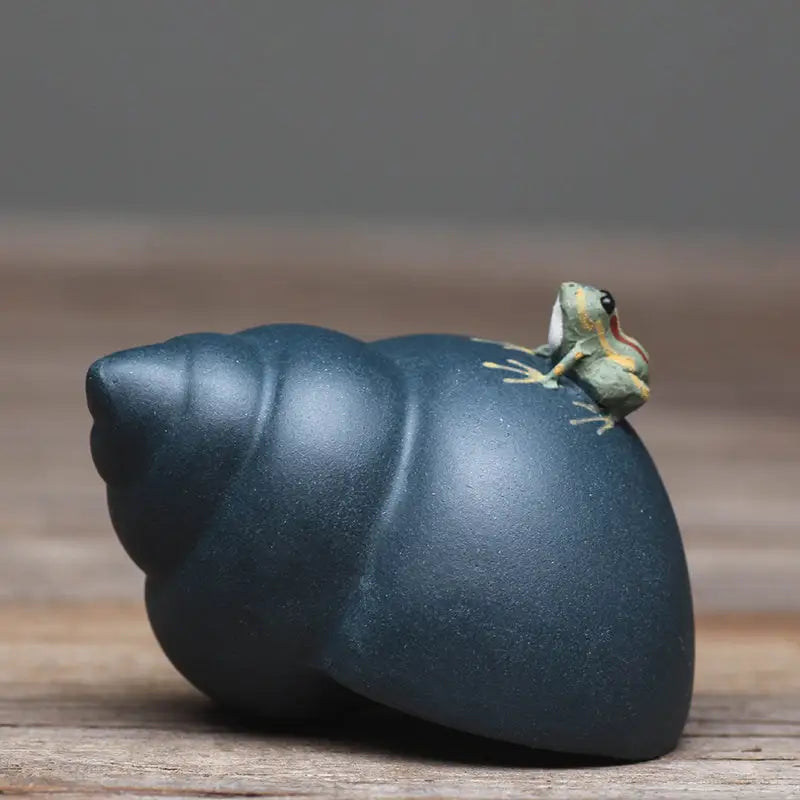 Raincaller frog atop dark blue Yixing clay teapot shell, perfect for tea pets guide