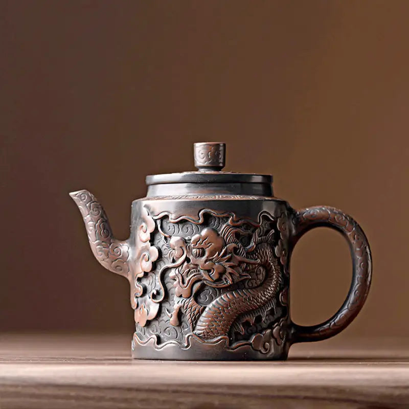 Ornate bronze relief dragon teapot made from Jianshui Zitao clay showcasing intricate dragon design