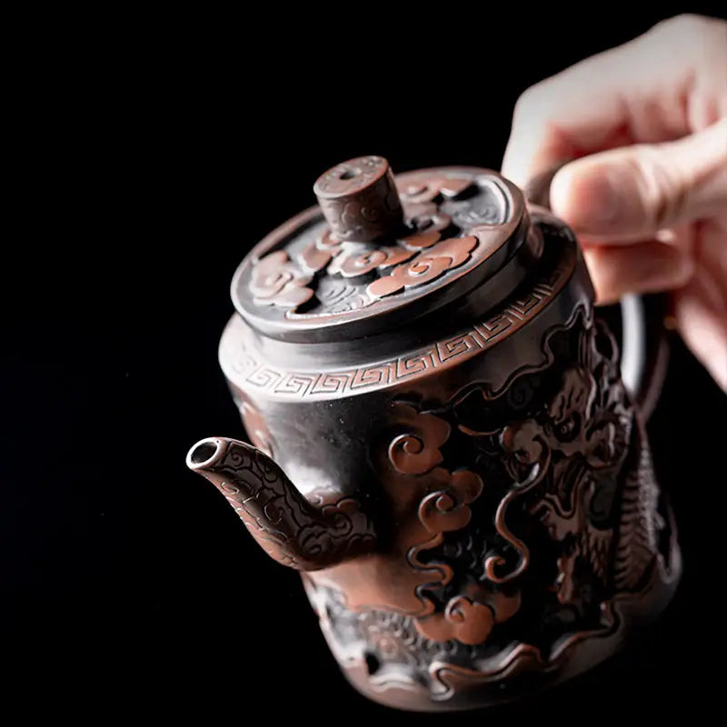 Ornate bronze relief dragon teapot crafted from Jianshui Zitao clay featuring intricate dragon design