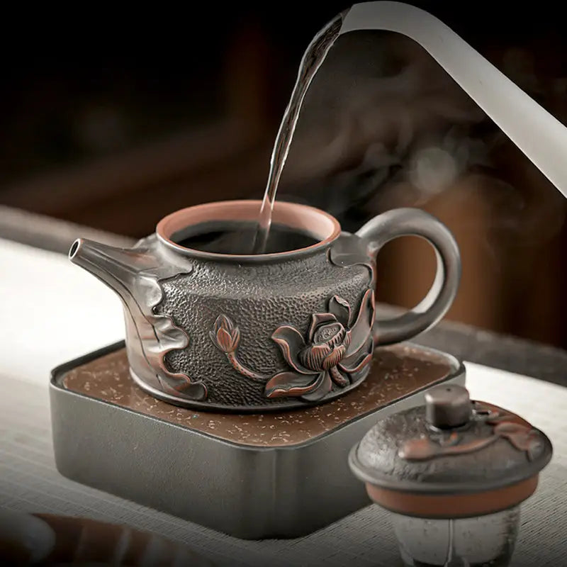 Ornate Relief Lotus teapot in Jianshui Zitao black clay with floral relief design