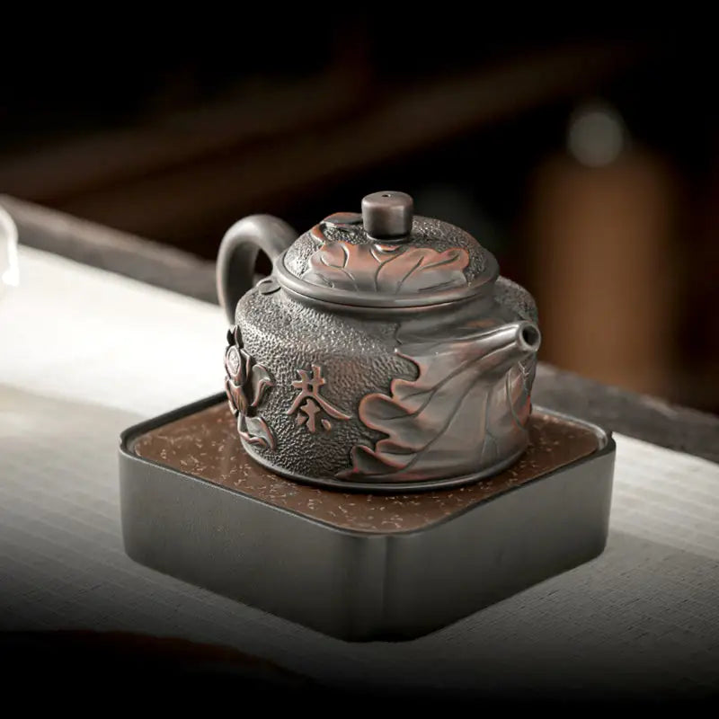 Ornate metallic teapot from Relief Lotus handcrafted in Jianshui Zitao black clay