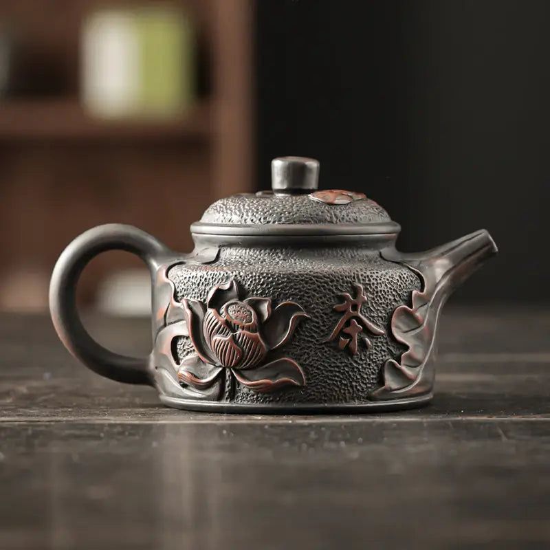 Ornate Relief Lotus Jianshui Zitao black clay teapot with dark-toned design