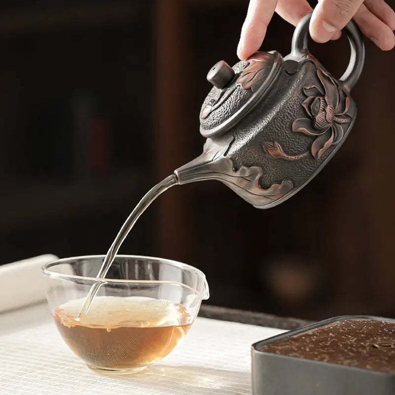 Ornate Relief Lotus Jianshui Zitao black clay metal teapot pouring tea