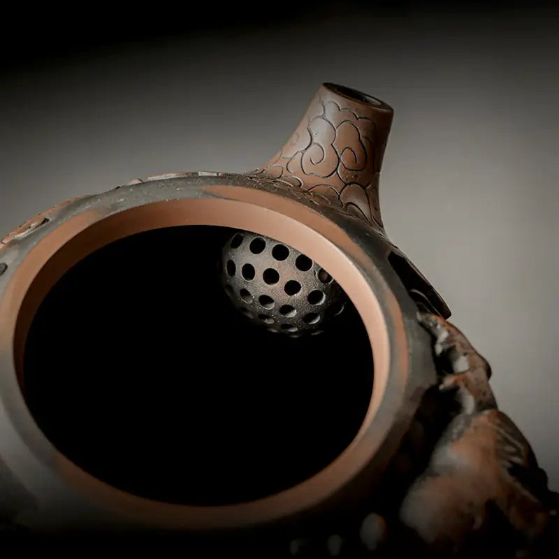 Ornate brown Jianshui Zitao teapot with perforated ball and hand-carved dragon design