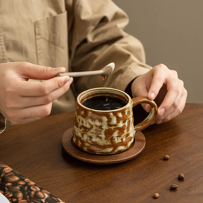 Rustic brown and white handmade Dehua ceramic mug with unique oxidation on wood saucer