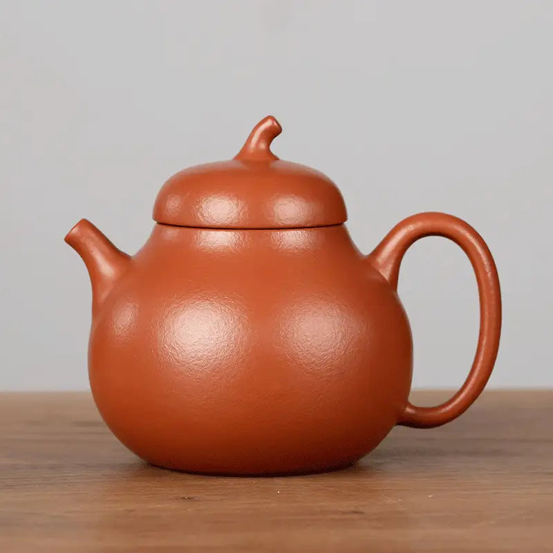 Earthenware teapot from Serenity Glow Tea Set, crafted in Yixing Zisha clay with a rounded body