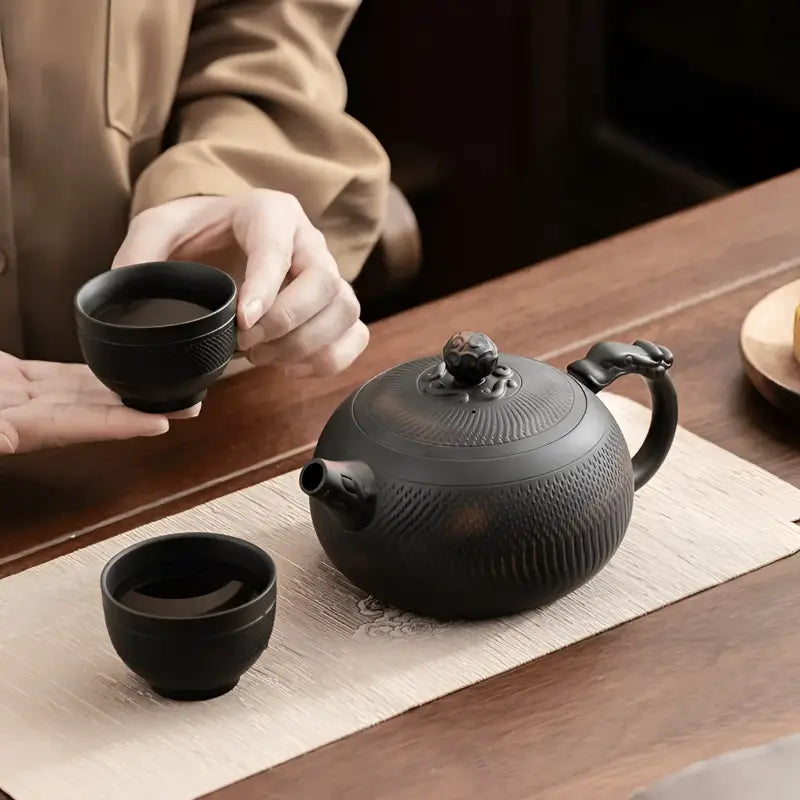 Shadow Lion Yixing Zisha teapot set with black cast iron teapot and cups for elegant tea brewing
