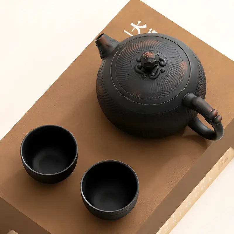 Shadow Lion Yixing Zisha teapot set with a black ceramic teapot and cups for elegant tea brewing