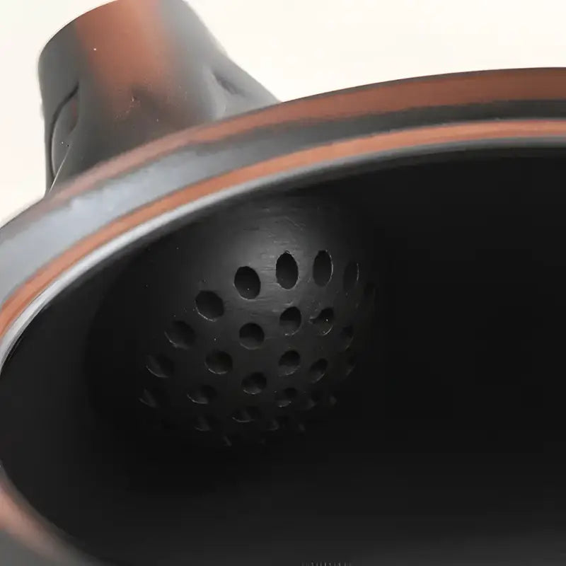 Dark perforated spherical filter in Shadow Lion Yixing Zisha teapot set for brewing
