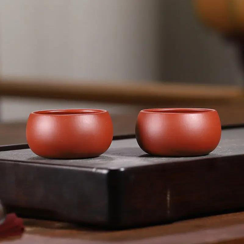 Two reddish-brown silent curve cups made of Yixing Zisha clay for Gongfu tea brewing