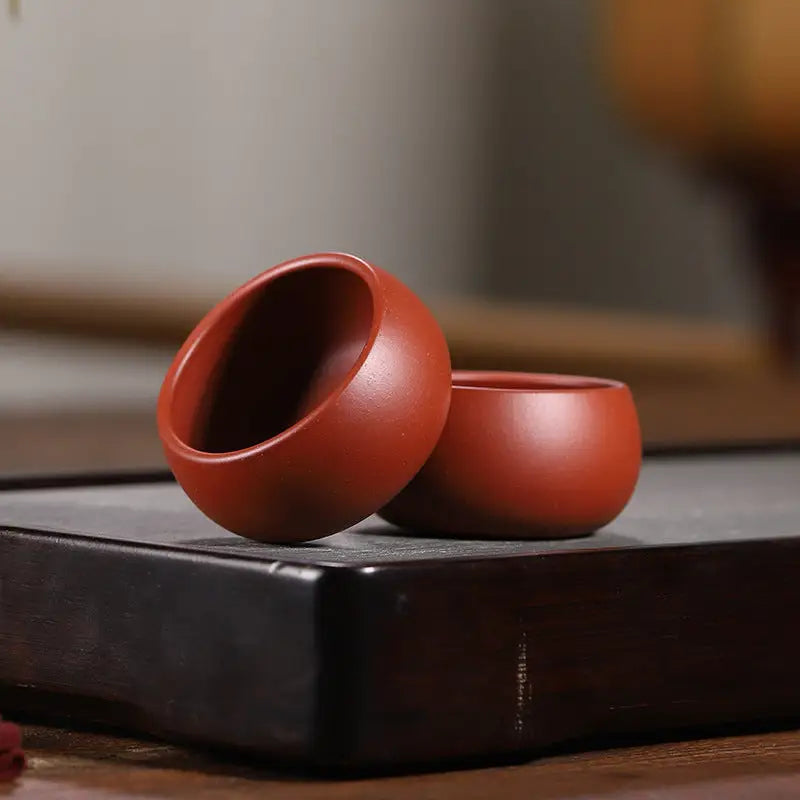 Two reddish-brown silent curve cups made from Yixing Zisha clay for Gongfu tea brewing