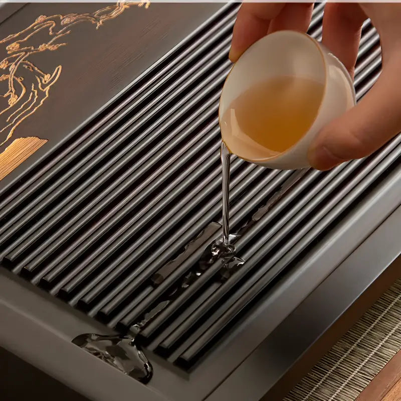 Silent Grove bamboo gongfu tea table with tea being poured onto a black tray