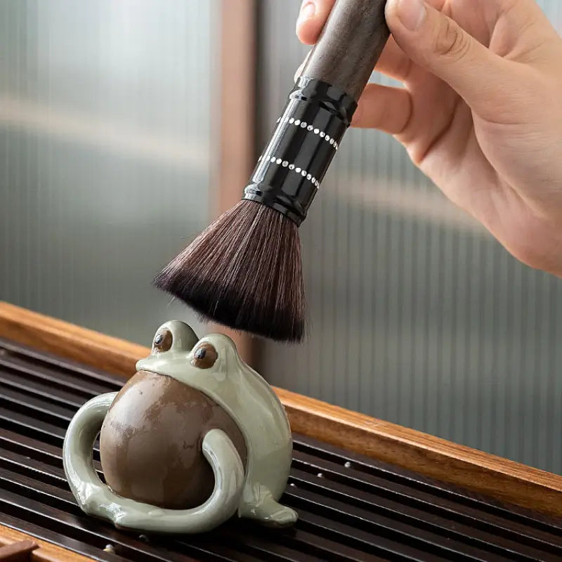Ceramic frog tea pet being brushed with Six Gentlemen Tea Set for gongfu tea ceremony