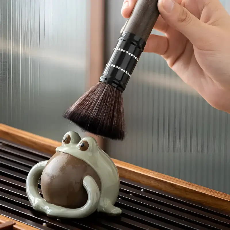 Ceramic frog tea pet being brushed with Six Gentlemen Tea Set for gongfu tea ceremony