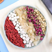 Assorted dried ingredients on a plate for herbal tea to enhance sleep quality and reduce hair loss