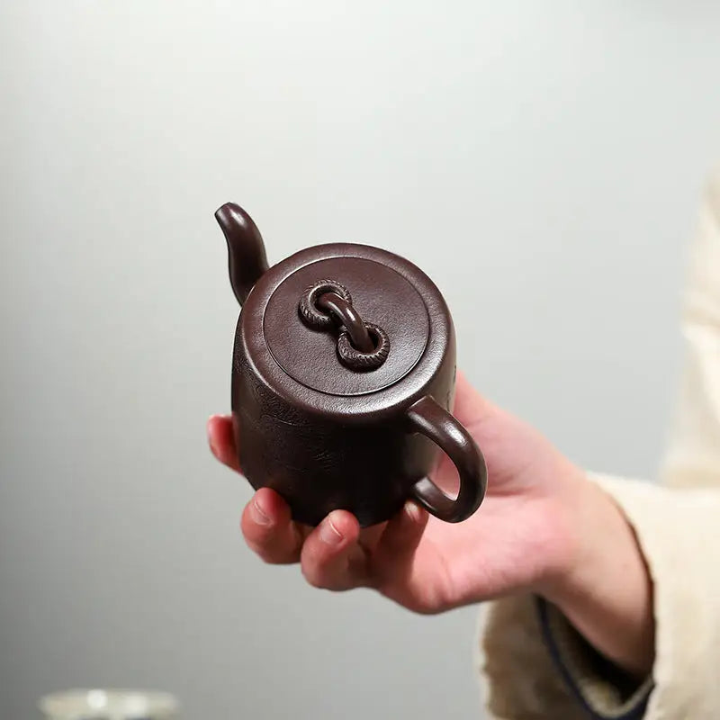 Brown ceramic teapot from Soaring Tranquility featuring a carved crane and pine motif