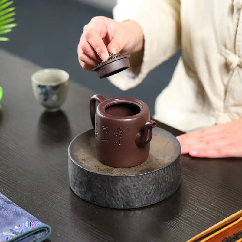 Brown ceramic Yixing Zisha Teapot with carved crane and pine motif in Soaring Tranquility