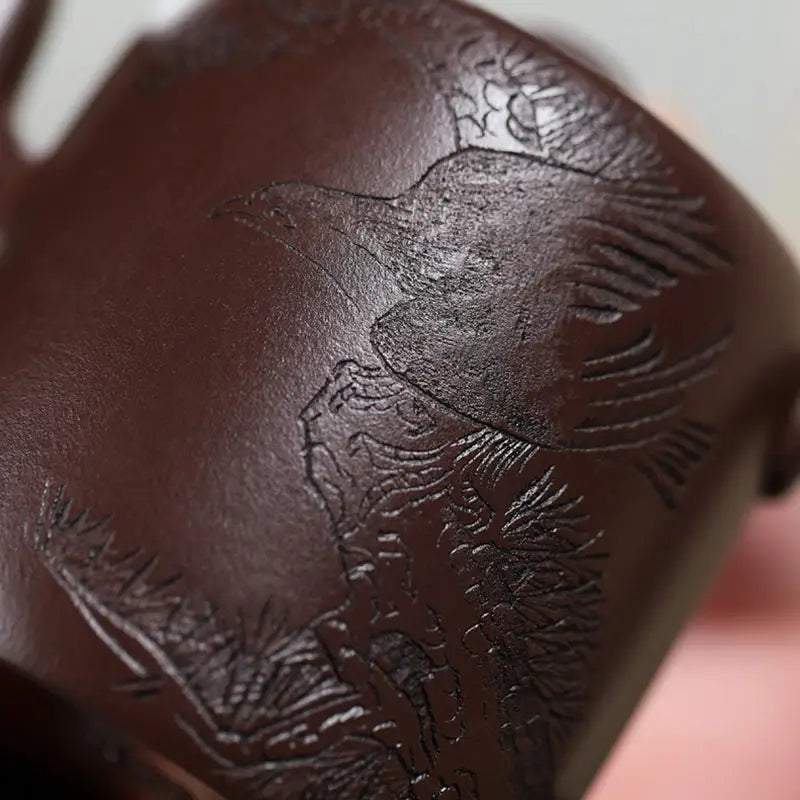 Dark brown Yixing Zisha teapot with carved crane and pine motif designs