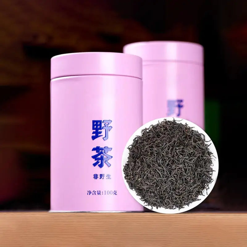 Pink tea canisters and dark Sou Chong Red Tea Leaves with teapots and mugs showing freshness