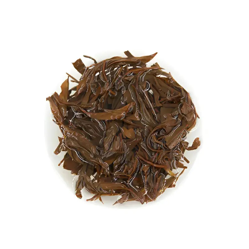 Pile of dark, wet Tanyang Black Tea leaves with delicate floral aroma and elegant floral notes