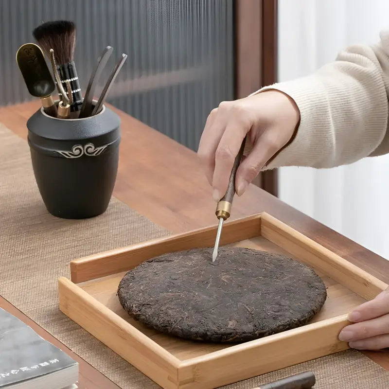 Puer tea cake being pierced with Gongfu Tea Ceremony Tool Set from Six Gentlemen
