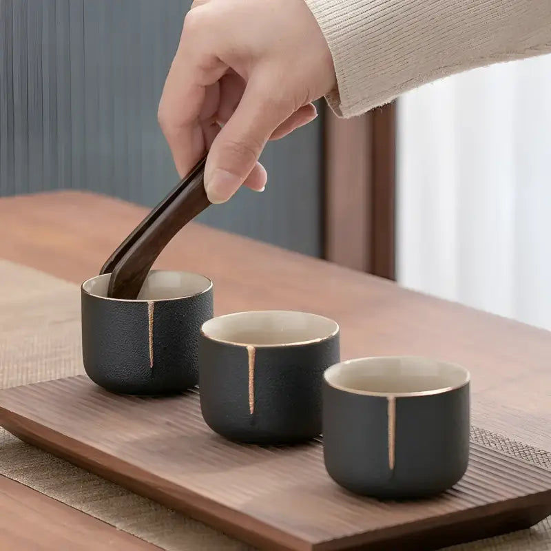 Three black tea cups with gold trim from Gongfu Tea Six Gentlemen Ceremony Tool Set