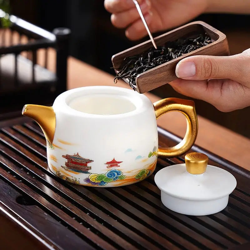 Decorated white ceramic teapot with golden accents showcasing Jingdezhen enamel art in The Dragon