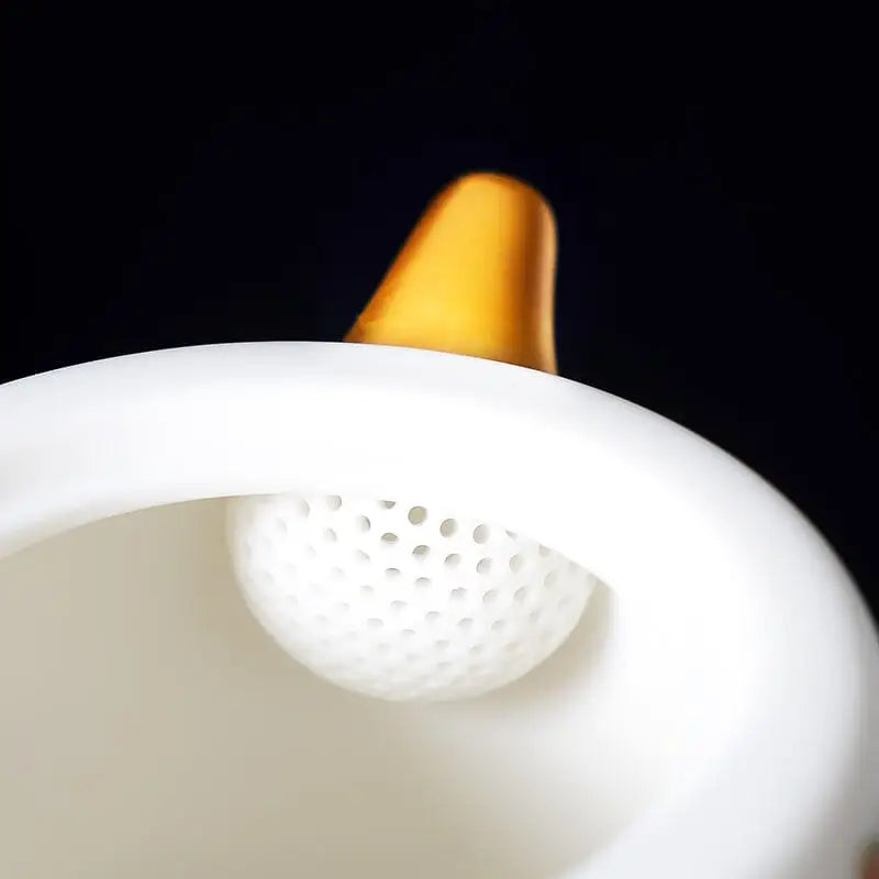 White ceramic teapot with infuser featuring golden accents, part of the Jingdezhen enamel art collection