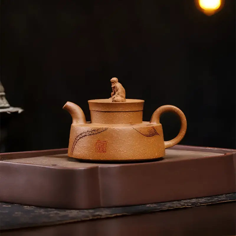 Earthenware teapot with monk figurine showcasing Yixing Zisha craftsmanship named The Hermit