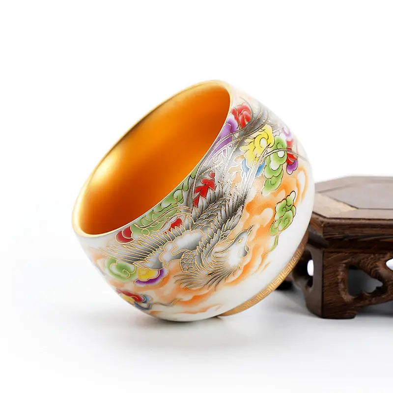 Ornate porcelain tea cup with golden interior from The Phoenix for gongfu tea brewing