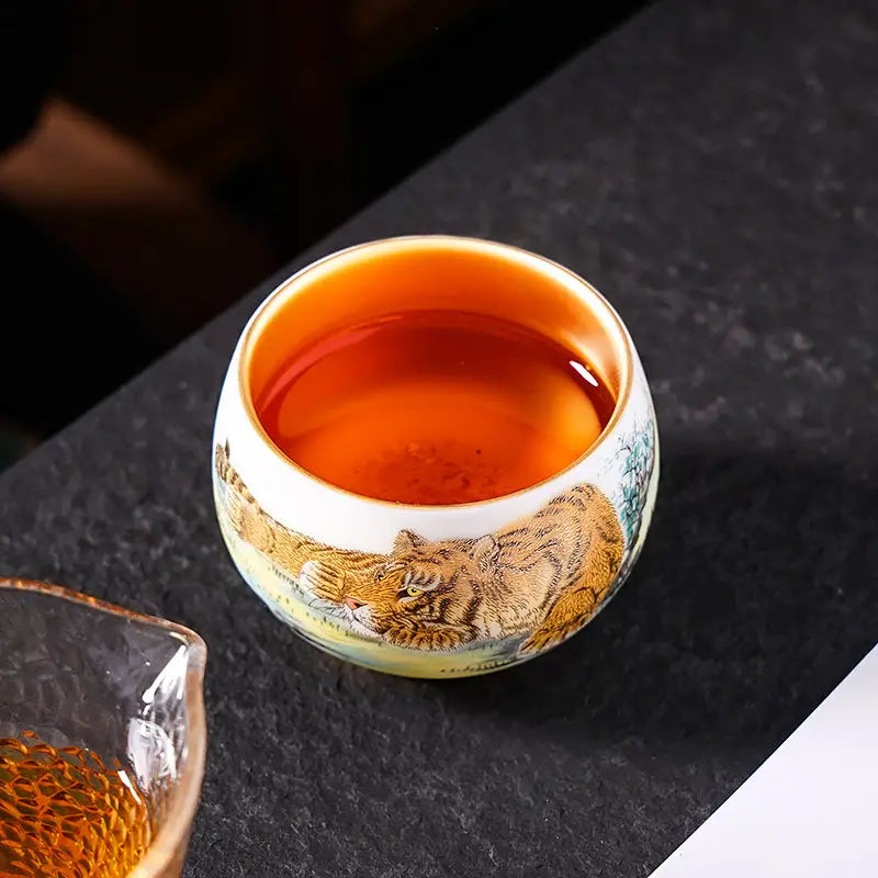 Tiger-themed tea cup filled with amber liquid, perfect for Gongfu tea enthusiasts