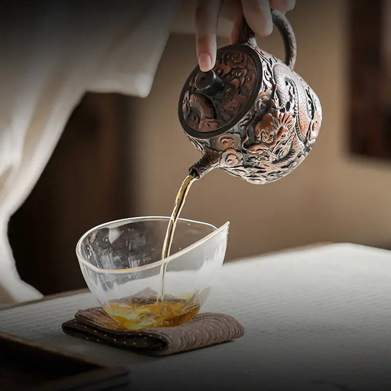 Ornate three-dimensional dragon-themed Jianshui Zitao teapot pouring tea