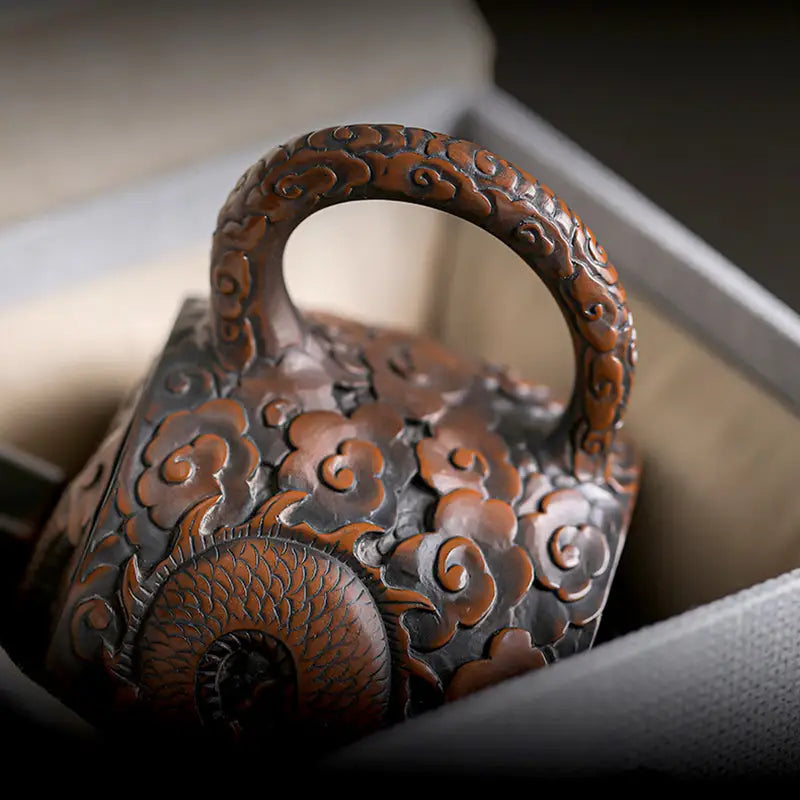 Ornate three-dimensional dragon carved jianshui zitao teapot with cloud motifs