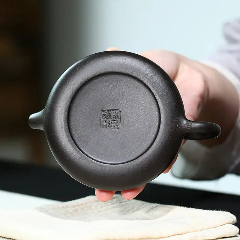 Dark clay teapot base from Twilight Plum Yixing with hand-painted plum blossoms in black Zisha clay