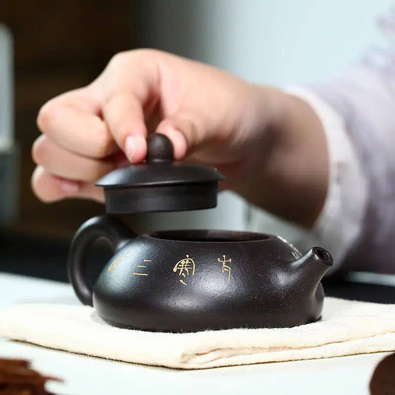 Dark brown Twilight Plum Yixing teapot with lid, hand-painted plum blossoms on black Zisha clay