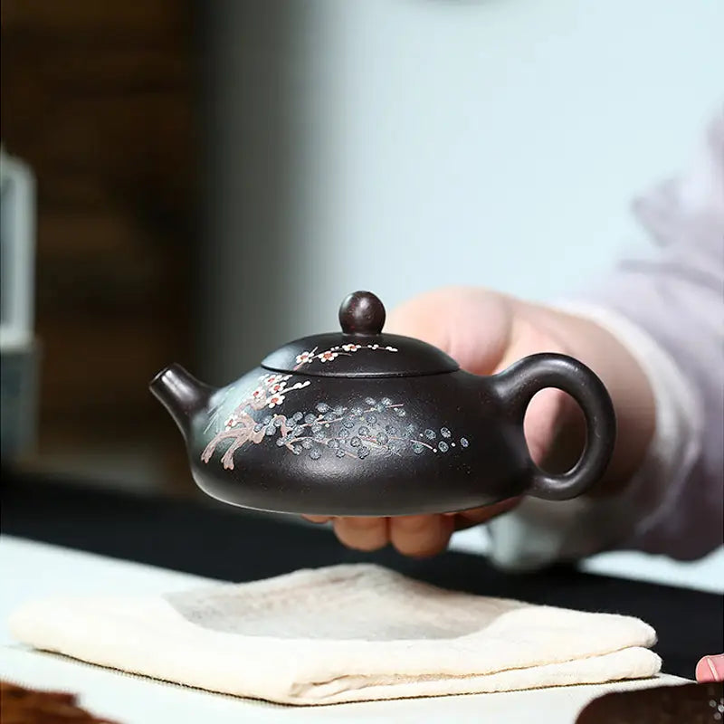 Dark brown Twilight Plum Yixing teapot with hand-painted plum blossoms in black Zisha clay