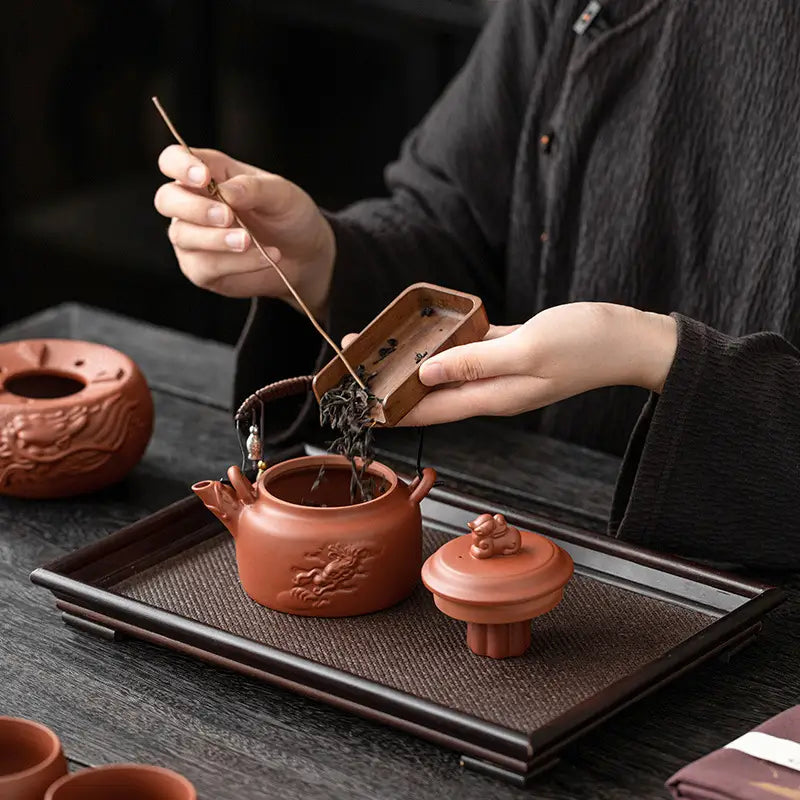 Vermilion Harmony Tea Set with dragon motif in Yixing Zisha clay featuring earthenware style
