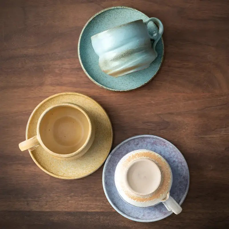 Three Whispering Earth ceramic coffee cups and saucers for elegant coffee enjoyment