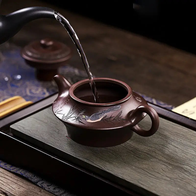 Brown ceramic Yixing Zisha teapot from Whispering Quail being filled with hot water