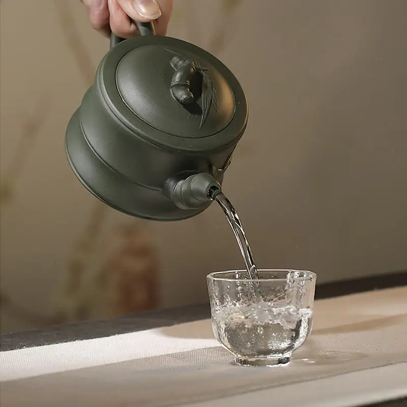 Green Duanni Zisha teapot pouring water, part of the Whispers of Bamboo collection
