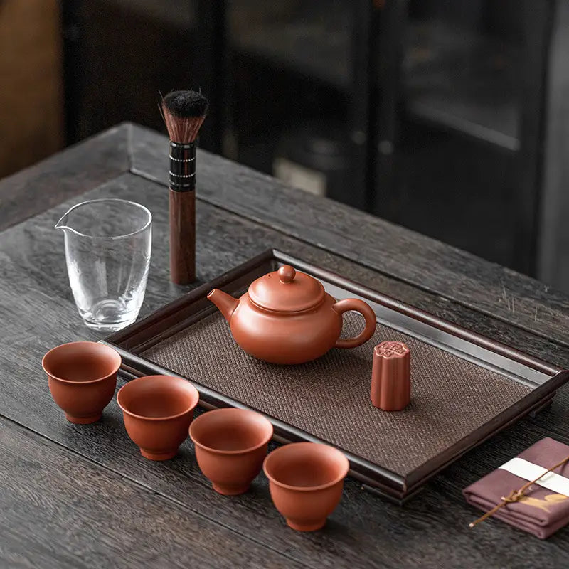 Whispers of Clay Tea Set on woven tray showcases Yixing Zisha clay tea set style