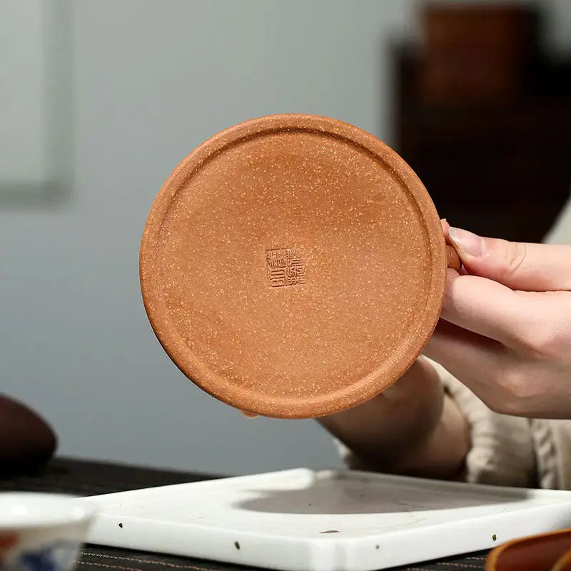 Round textured reddish-brown ceramic coaster from Wind Dragon, inspired by Yixing Zisha pottery