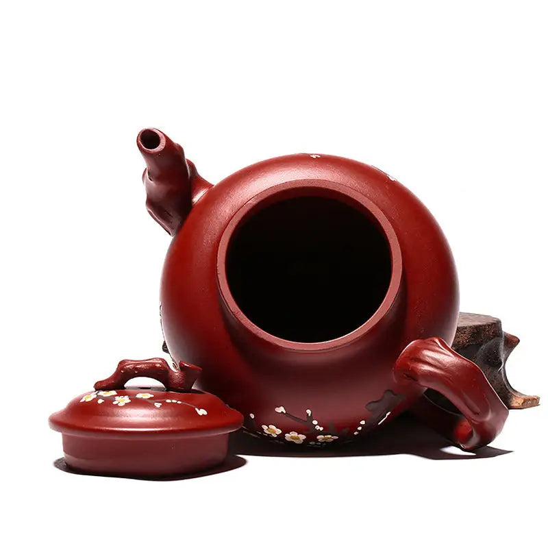 Reddish-brown Yixing teapot with hand-painted plum blossoms in authentic Zisha clay