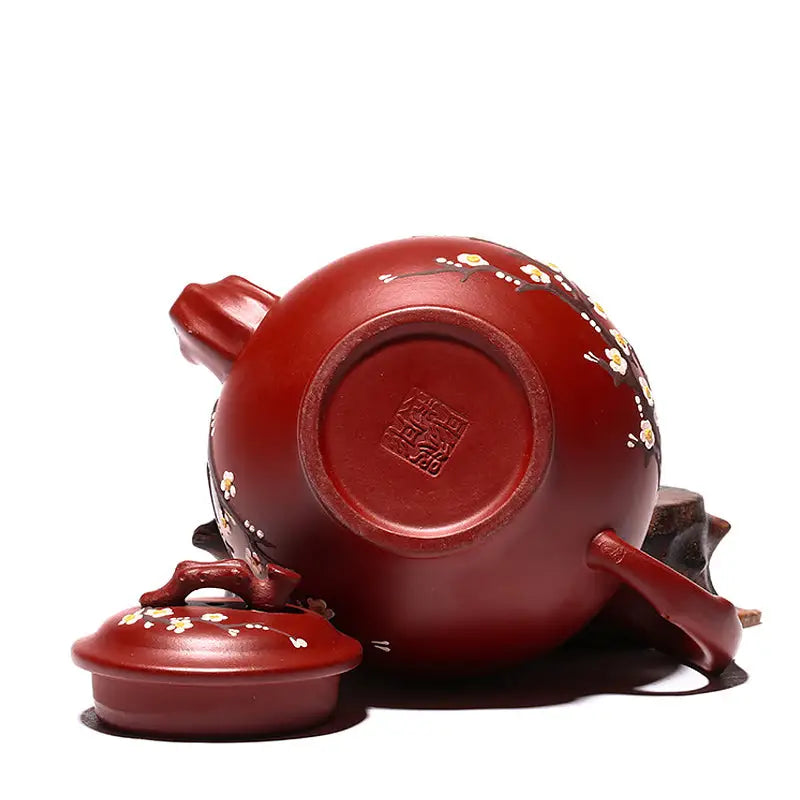 Reddish-brown Yixing teapot with hand-painted plum blossoms in authentic Zisha clay