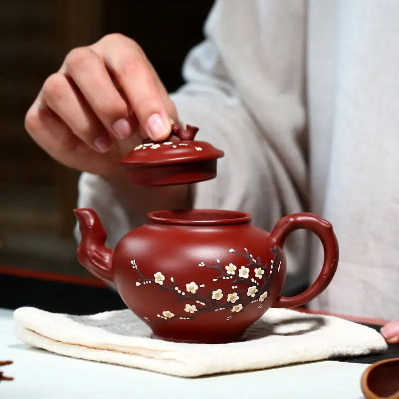 Reddish-brown Yixing teapot with hand-painted plum blossoms in authentic Zisha clay for Winter Bloom