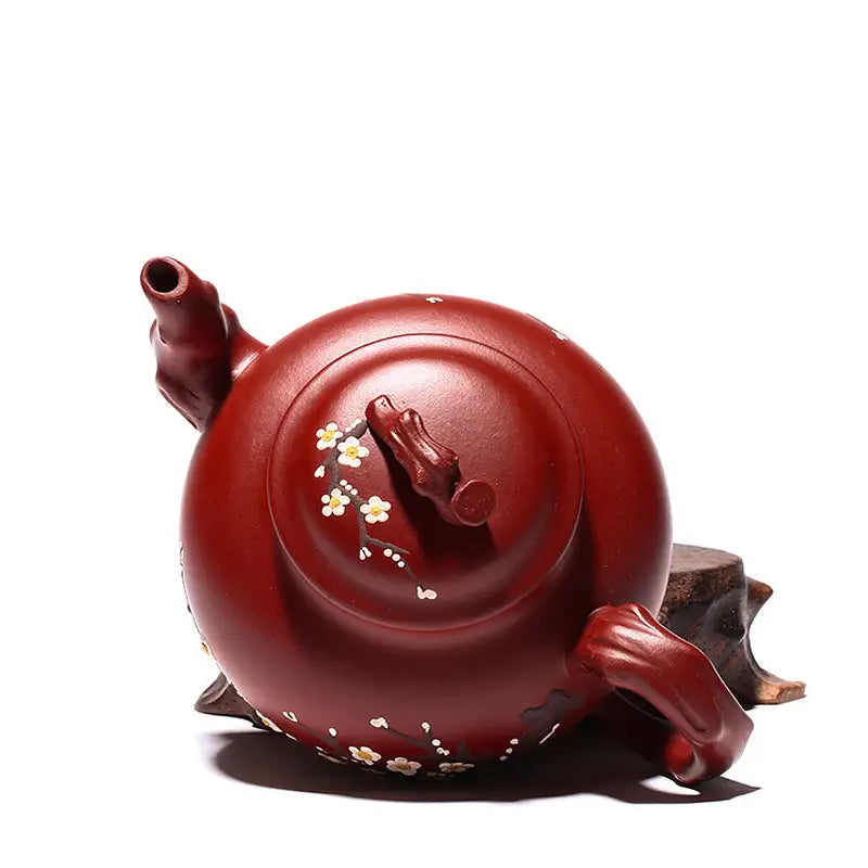 Reddish-brown Yixing teapot with hand-painted plum blossoms in authentic Zisha clay